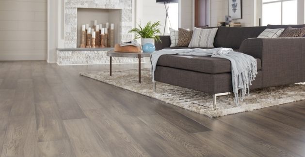stylish living room with gray-toned vinyl plank flooring and large gray sofa
